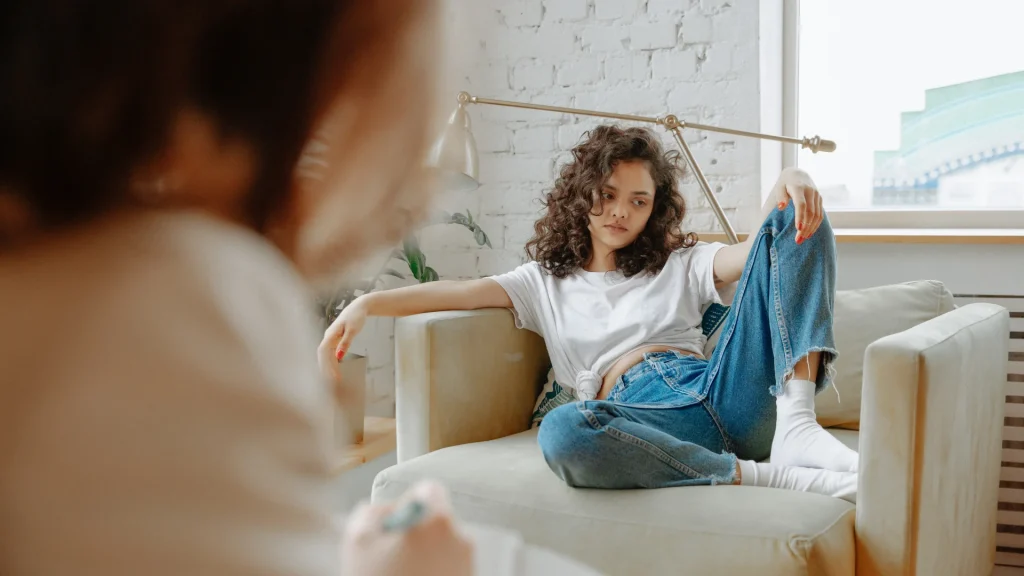 A young woman sits across from her psychotherapist.